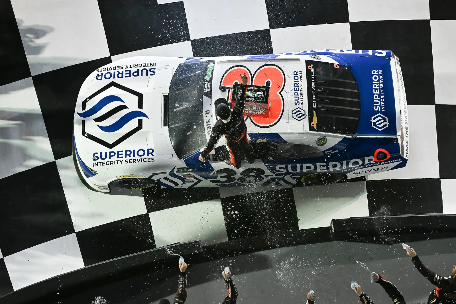 Ryan Sieg stands on the roof of the No. 38 on the checkered start-finish line as the celebration begins.